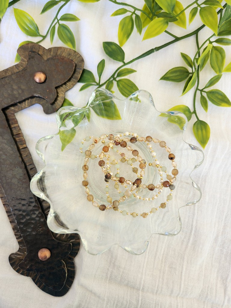 Delicate beaded bracelets in a scalloped glass bowl