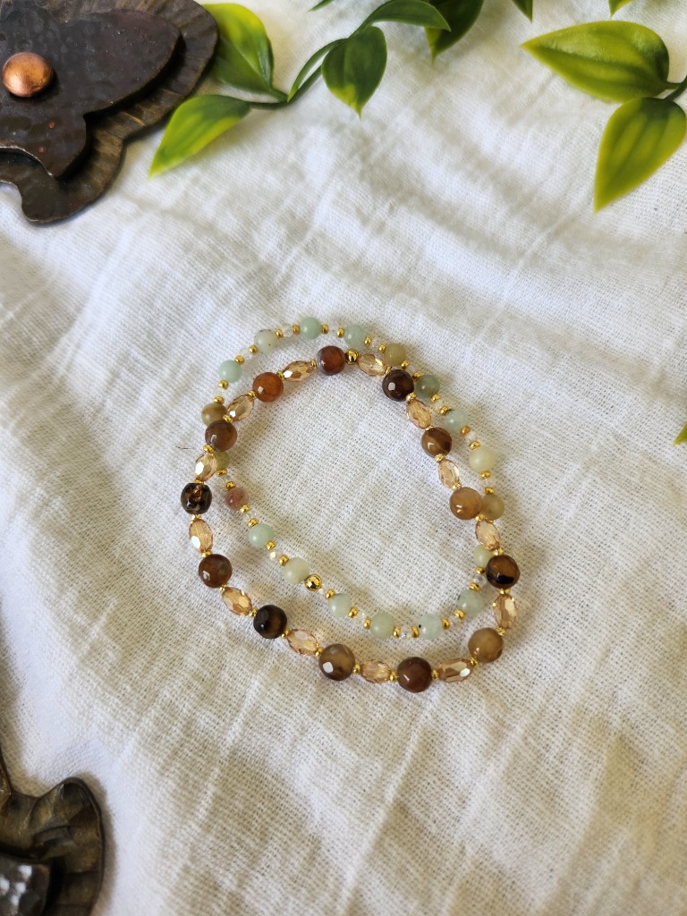 Two earthy beaded bracelets on white linen