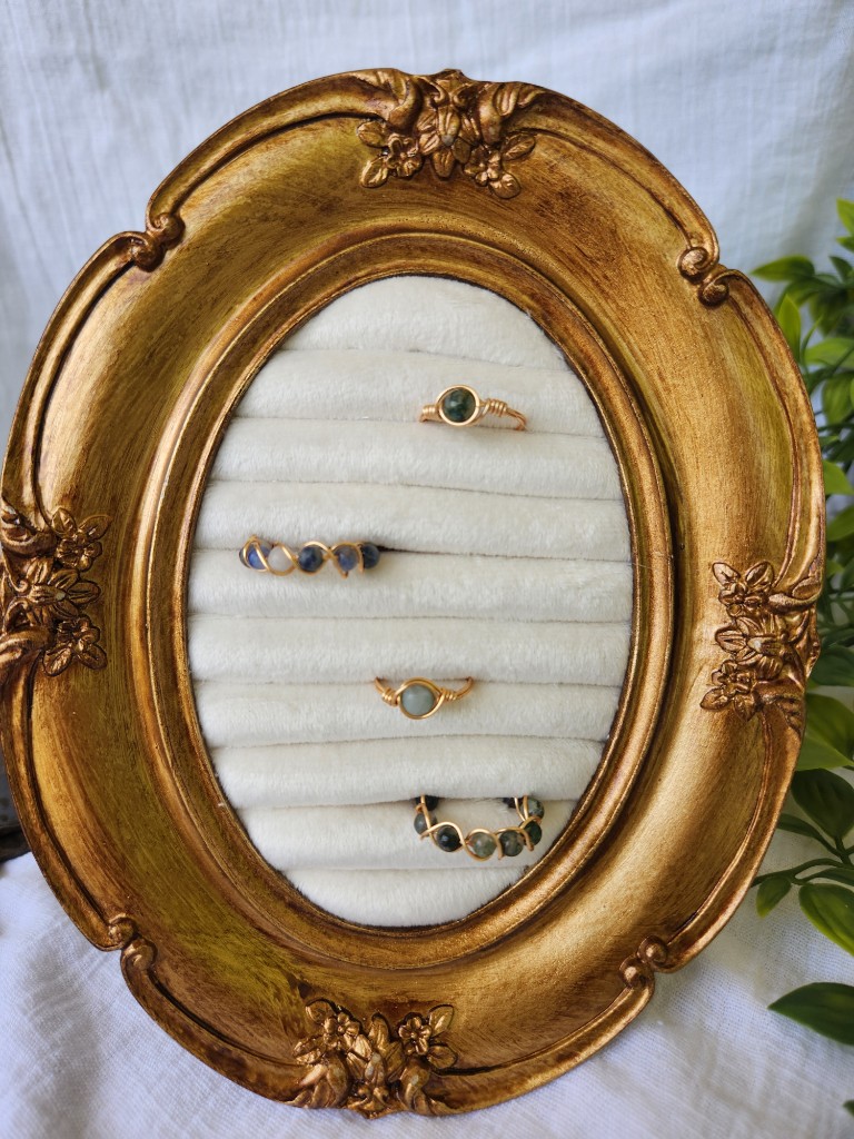 Wire-wrapped rings in a gold frame